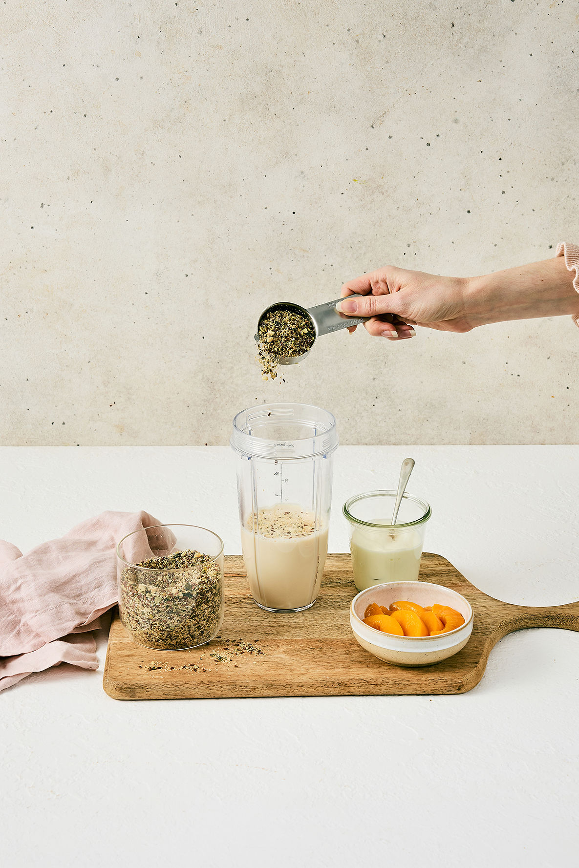 Adding a quarter-cup scoop of My Daily Gut to a smoothie